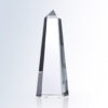 Clear crystal obelisk trophy with pointed top on flat surface, suitable for corporate or employee recognition awards.