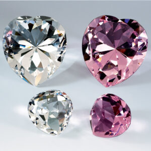 Heart-shaped crystal trophies in clear and pink, large and small, displayed for corporate recognition or milestone awards.
