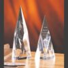 Crystal pyramid trophies, including the Apex Crystal Award, on wood table; ideal for corporate or milestone recognition.