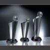 Silver crystal trophy awards with faceted crystal tops on a reflective surface, ideal for corporate recognition or milestones.