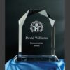 Crystal glass plaque with beveled edges on blue cloth, engraved for a humanitarian award recognizing outstanding achievement.