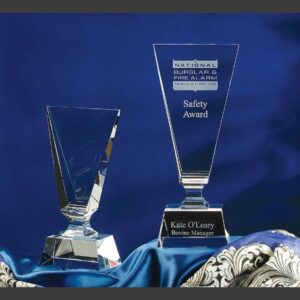Crystal award trophies on blue satin; one engraved for safety recognition, one blank for customizable corporate awards.
