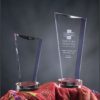 Crystal trophy awards with angled tops on round bases, ideal for corporate or employee leadership recognition.