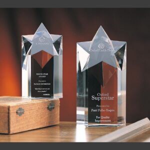 Crystal star awards displayed on wood surface; ideal for corporate or employee recognition. Clear crystal with star-shaped tops.