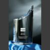 Curved crystal trophy with American Express logo, honoring 20 years of service, on a blue satin cloth.