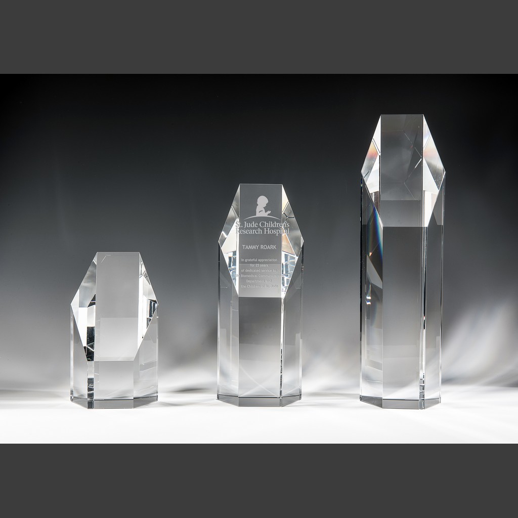 Crystal trophy awards made of clear geometric glass, with engraved Natalie Crystal Award for corporate or employee recognition.