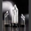 Pinnacle crystal awards on black bases, center piece for 50-year corporate milestone, clear geometric crystal trophies.