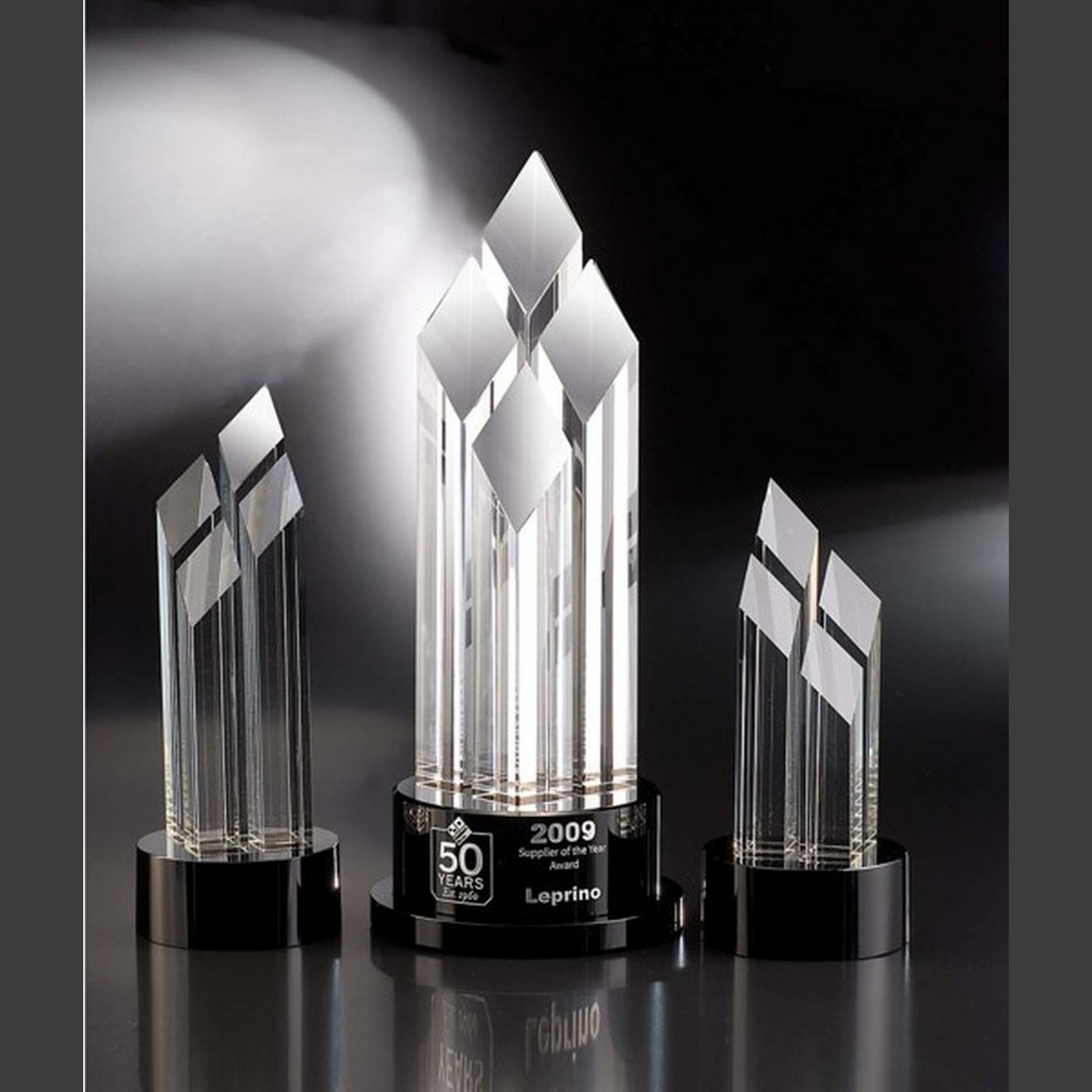 Pinnacle crystal awards on black bases, center piece for 50-year corporate milestone, clear geometric crystal trophies.