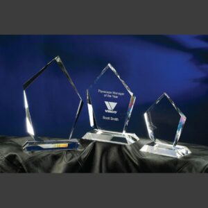 Summit crystal awards in three sizes on black cloth, center engraved for corporate achievement, ideal as manager trophies.