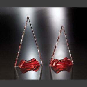 Crystal award trophies, including a red-based Soiree Crystal Award, displayed on reflective surface for corporate recognition.