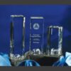 World Tower crystal awards with globe bases on black and blue satin, center piece engraved—ideal for corporate recognition.