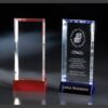 Crystal award plaques, one with a red base and one blue, ideal for corporate or employee recognition milestones. Glass material.