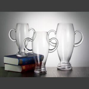 Crystal trophy cups with dual handles on books and table, ideal for corporate or employee achievement awards.