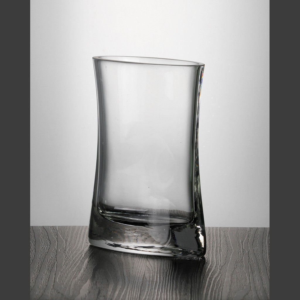 Curved asymmetrical crystal trophy award on dark surface, ideal for corporate recognition or milestone achievement.