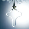 Crystal cross trophy hanging from a gold ribbon on a snow-covered branch, ideal for corporate or milestone recognition.