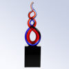 Crystal award trophy with intertwined red and blue glass loops on black base, ideal for corporate or employee recognition.
