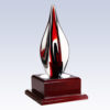 Crystal flame trophy with reflective finish on a dark wood base, ideal for corporate recognition or employee awards.