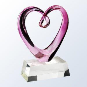 Heart-shaped crystal award with pink and clear glass, loop top, on a transparent base—ideal for corporate recognition.