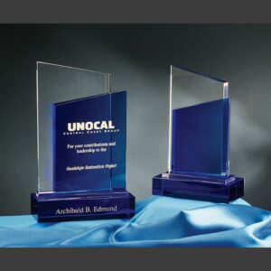 Bliss Crystal Award glass trophy with blue base for corporate recognition, displayed on a blue cloth.