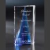 Crystal trophy with blue accent, engraved for Presidents Council sales achievement, shown on a dark background.