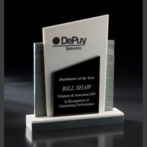 Crystal and marble award plaque recognizing top distributor performance, features DePuy Spine Inc. logo and recipient engraving.
